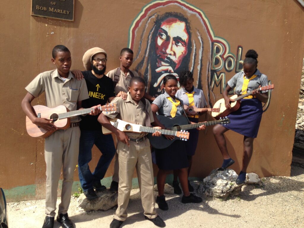 Aaron Nigel Smith poses with students in front of Bob Marly murel